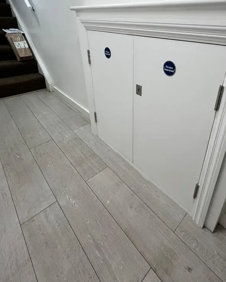 Job 1 after: new fire-rated meter cupboard doors with Fire Door Keep Shut signage