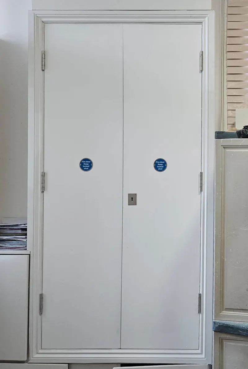 Pair of fire doors with Fire Door Keep Shut signage in a communal corridor