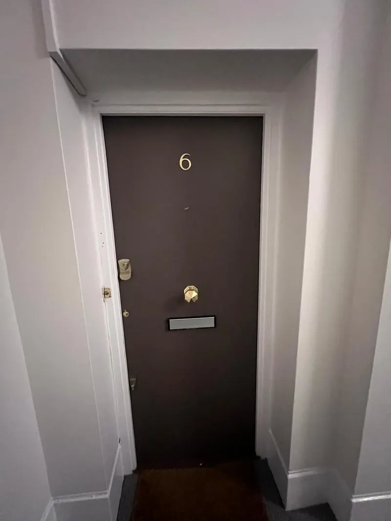 Fire door with Fire Door Keep Shut signage in a communal hallway