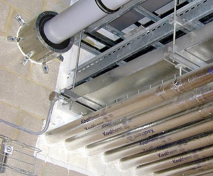 Service penetration fire stopping: pipes sealed through a fire-rated wall with fire batt and a pipe collar
