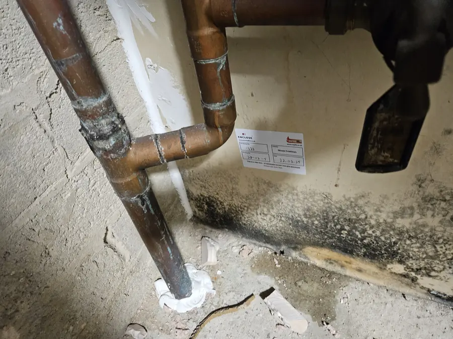 Copper pipes sealed with fire stopping, labelled