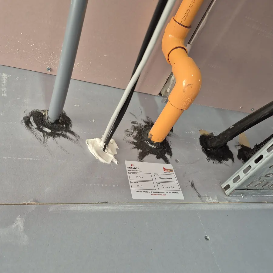 Plastic pipe with an intumescent fire collar, sealed and labelled