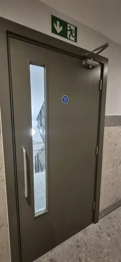 New fire door with vision panel and fire exit signage