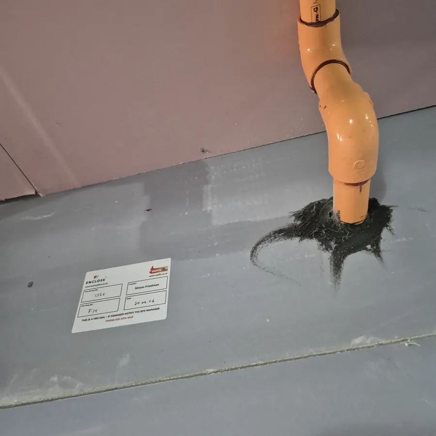 Pipe with fire collar through fire-rated board, labelled